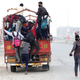 A migrant worker runs behind a truck as others try to board it to return to their villages.